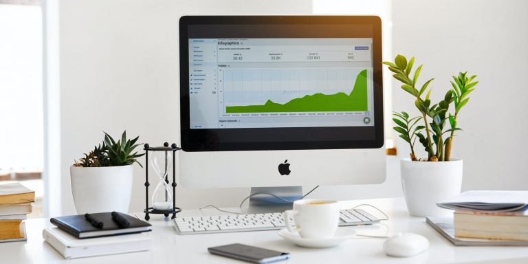 silver imac displaying line graph placed on desk