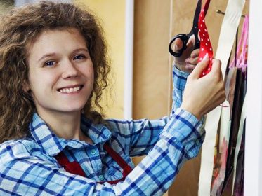 Female apprentice florist cutting some ribbon
