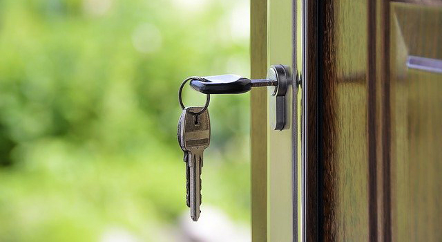 Image of open door with house keys sitting in lock