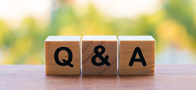 Three wooden blocks sit next to each other on a table, when read together and in order, the blocks read 'Q & A' with is an abbreviation for Questioned and Answered. 